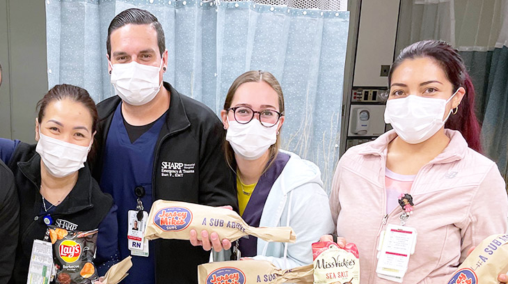 Sharp Memorial Hospital staff pose with donated Jersey Mike’s sandwiches during their shift